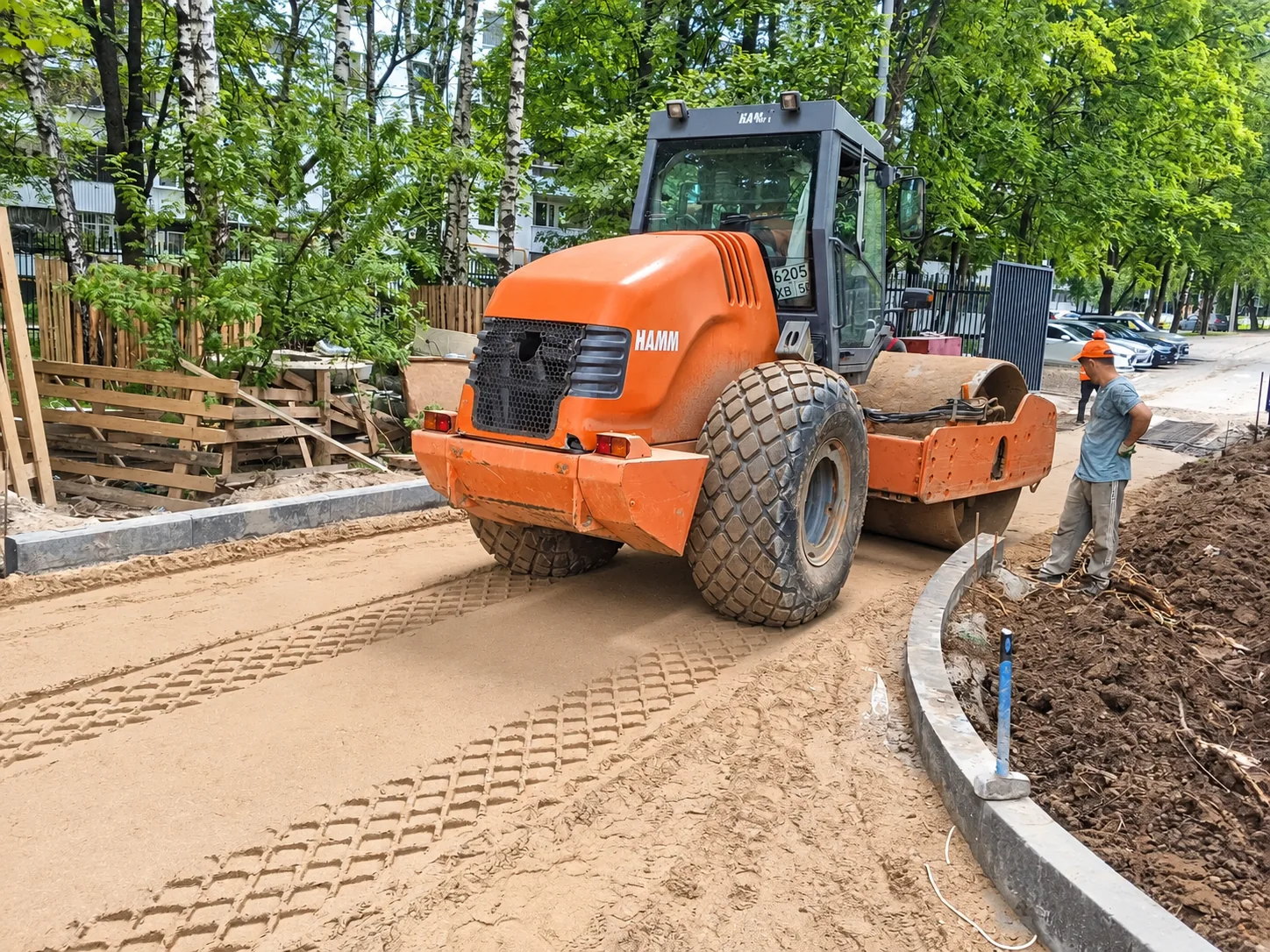Уплотнение основания дорожки катком